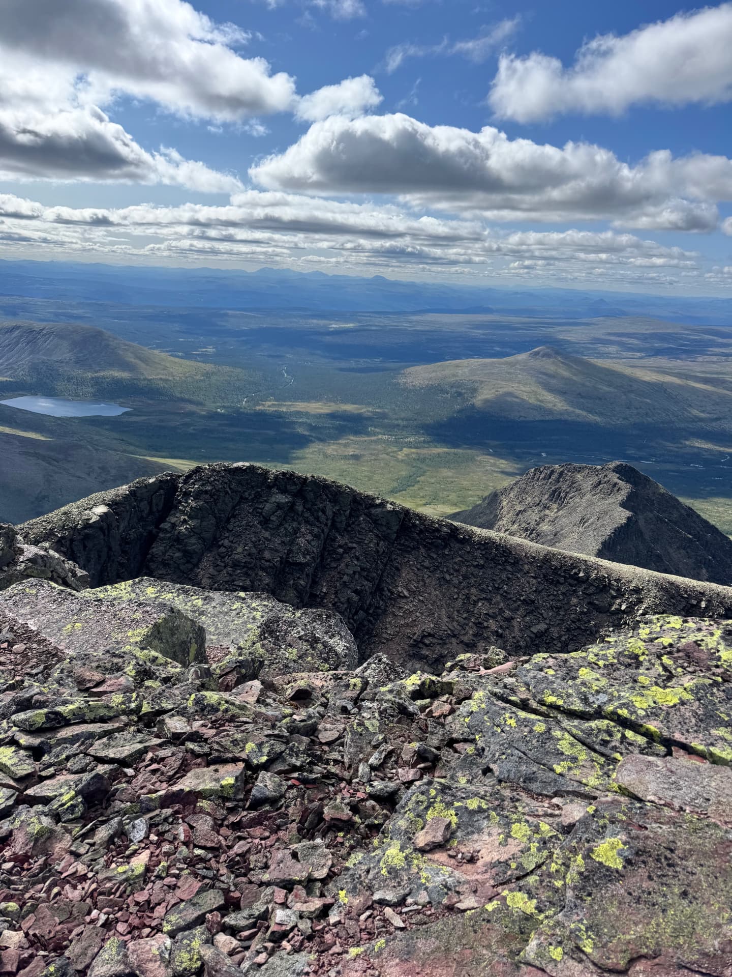 View from near the summit of Sølen with dark ridges falling away and the distant Rondane range on the horizon