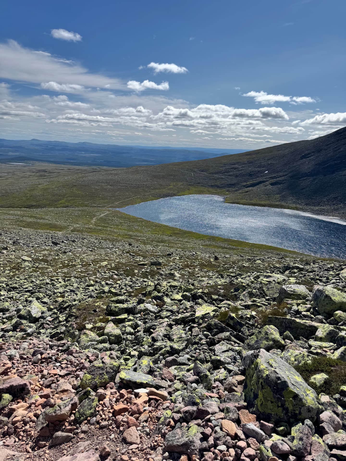 View back down the boulder-strewn slope to Skardstjønna lake with the wide plateau beyond